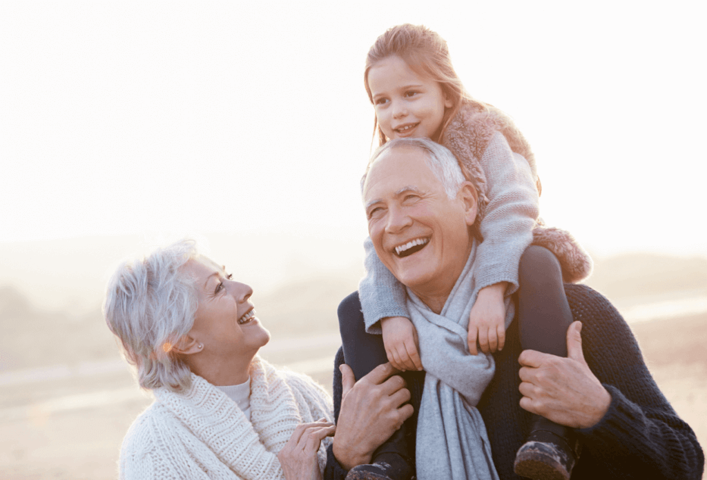 7 Best Health Insurance Plans for Retirees and Seniors Grandparents on the beach with child smiling.