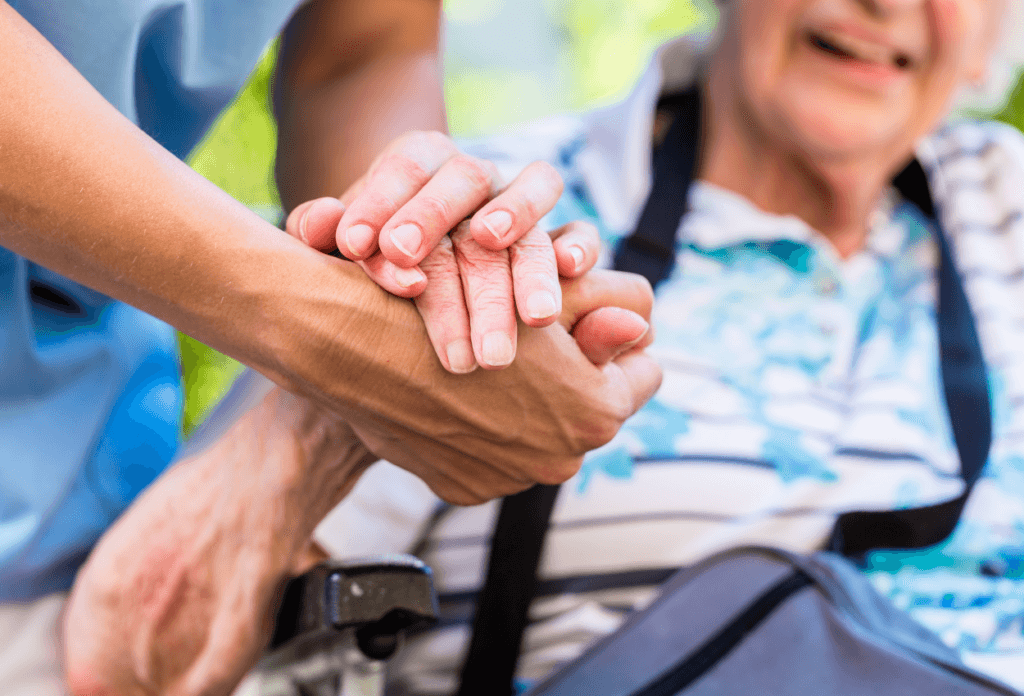 A picture of an senior woman holding a nurse's hand.