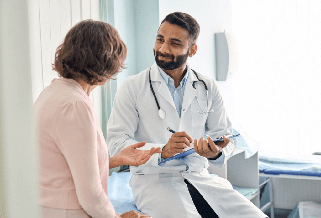 A male doctor smiling during a discussion with an older patient