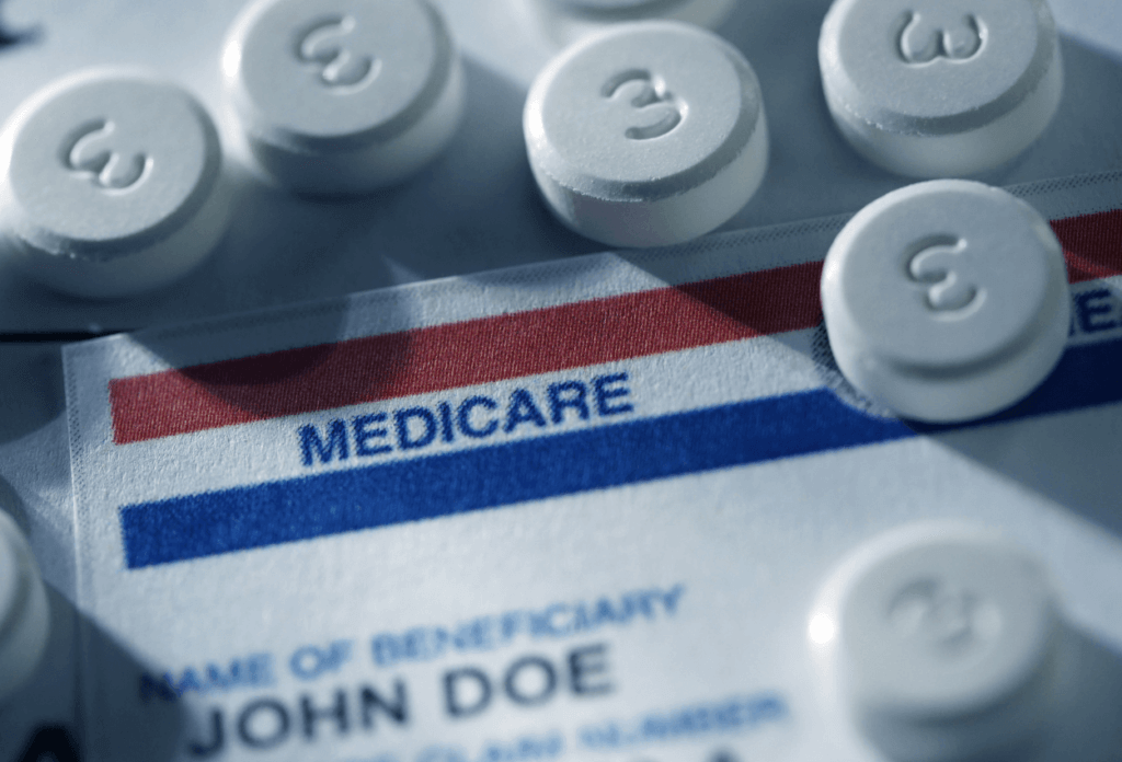 Some pills on a counter on top of a medicare card