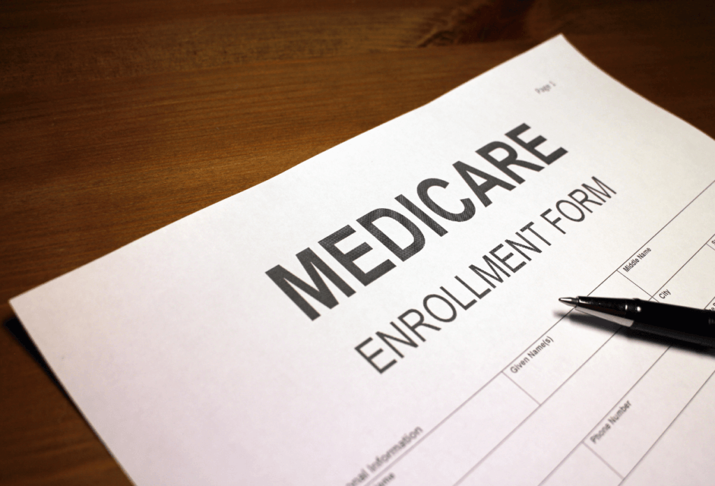 A blank Medicare enrollment form with a pen