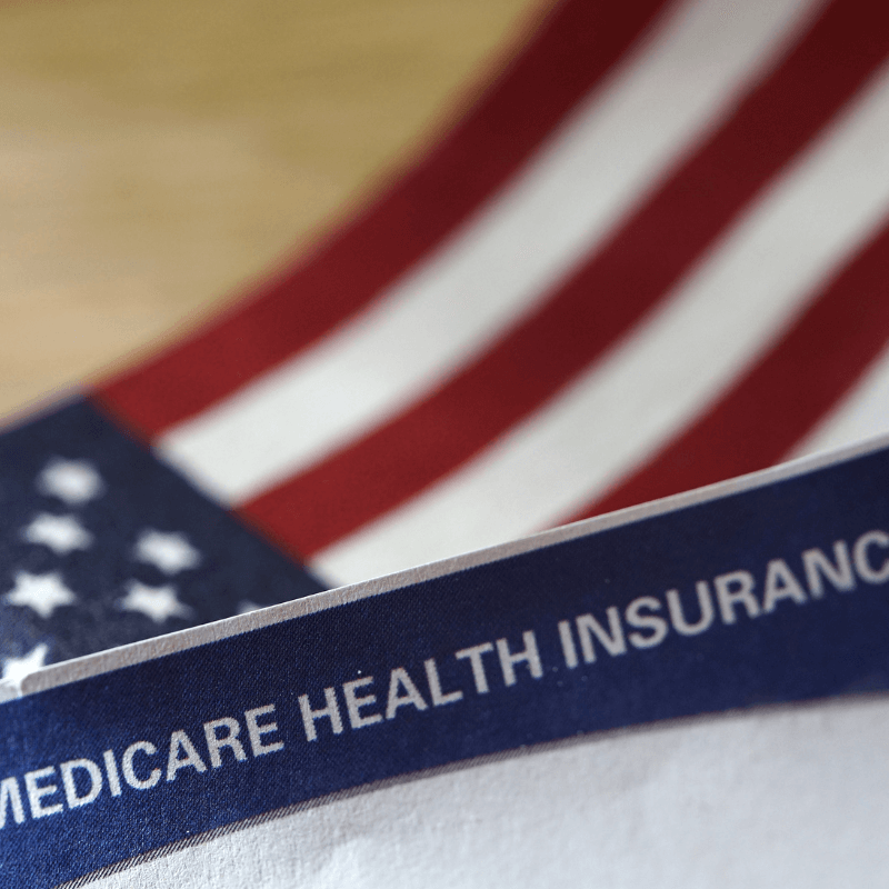 There's a Medicare Health Insurance card featured with an American flag in the background.