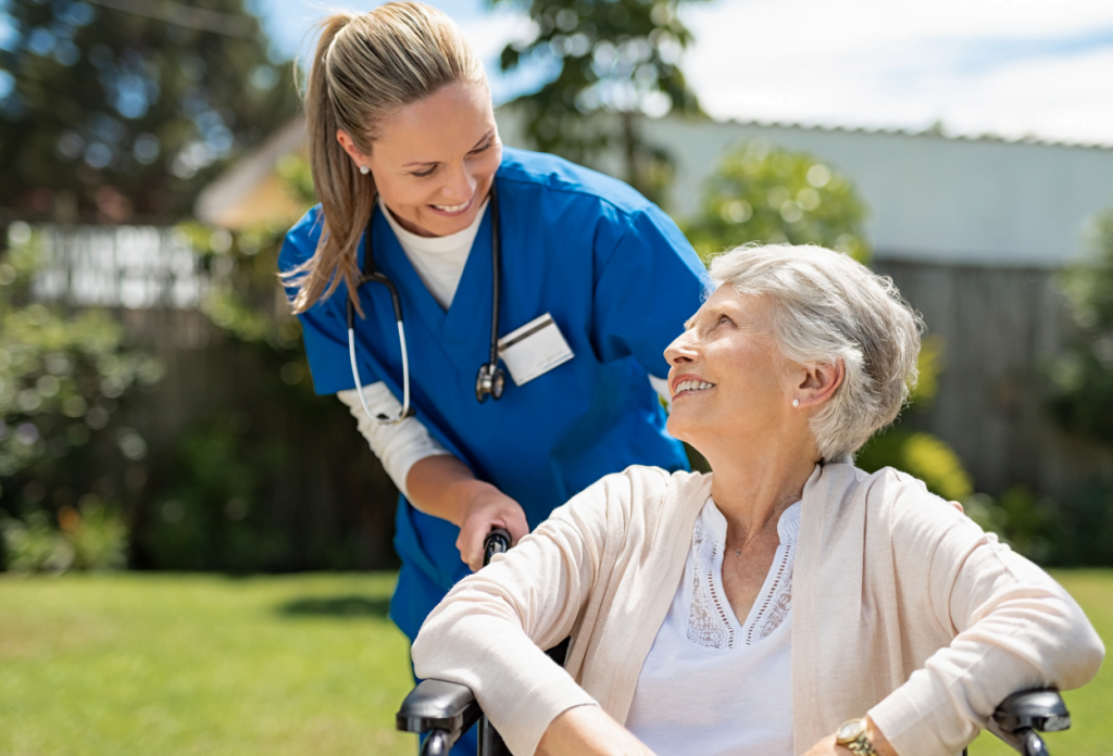 A female nurse is smiling at a senior woman in a wheelchair in a blog titled "Understanding Medicare for Chronic Illness: A Senior’s Path to Better Health."