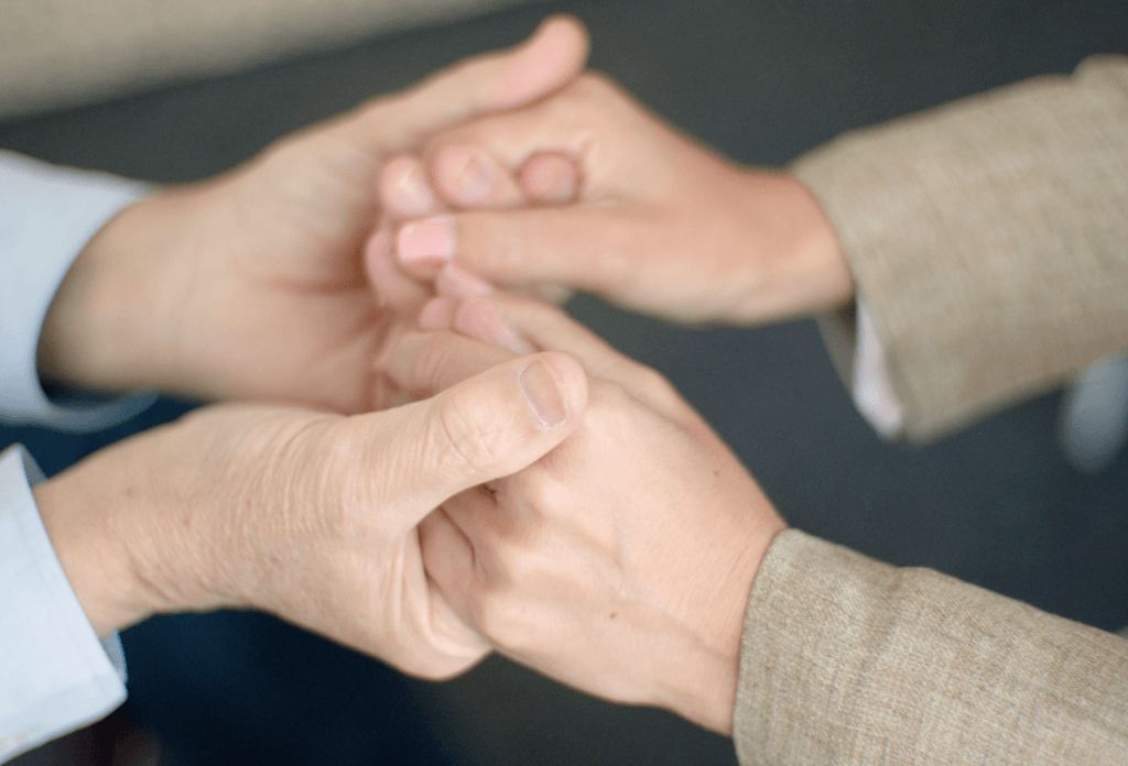 Seniors holding hands in support of one another.