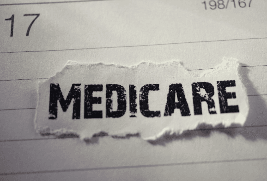 The word "Medicare" is on a piece of paper on a calendar in an image for a blog titled "Medicare Open Enrollment 2024-2025: Your Guide to Making the Right Choice."