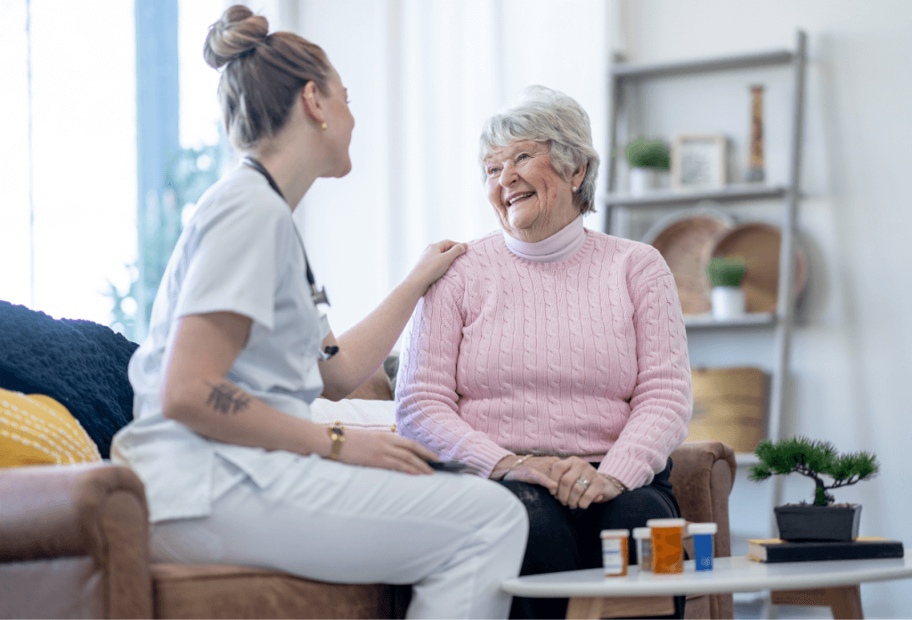 A female senior is smiling and talking with a nurse about Medicare with prescription medications.