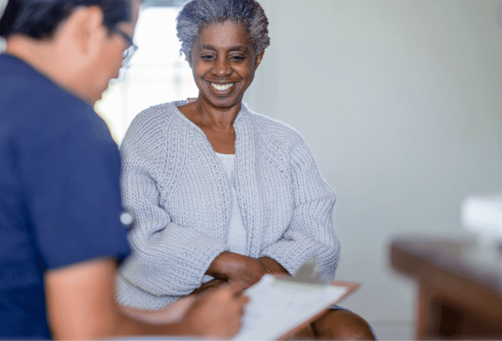 A female senior is going over health conditions with a nurse in a blog about Medicare and chronic illness.